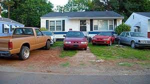 Cars parked on the front lawn of a house